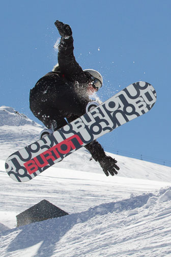 Snowboarder jumping, shot against the light